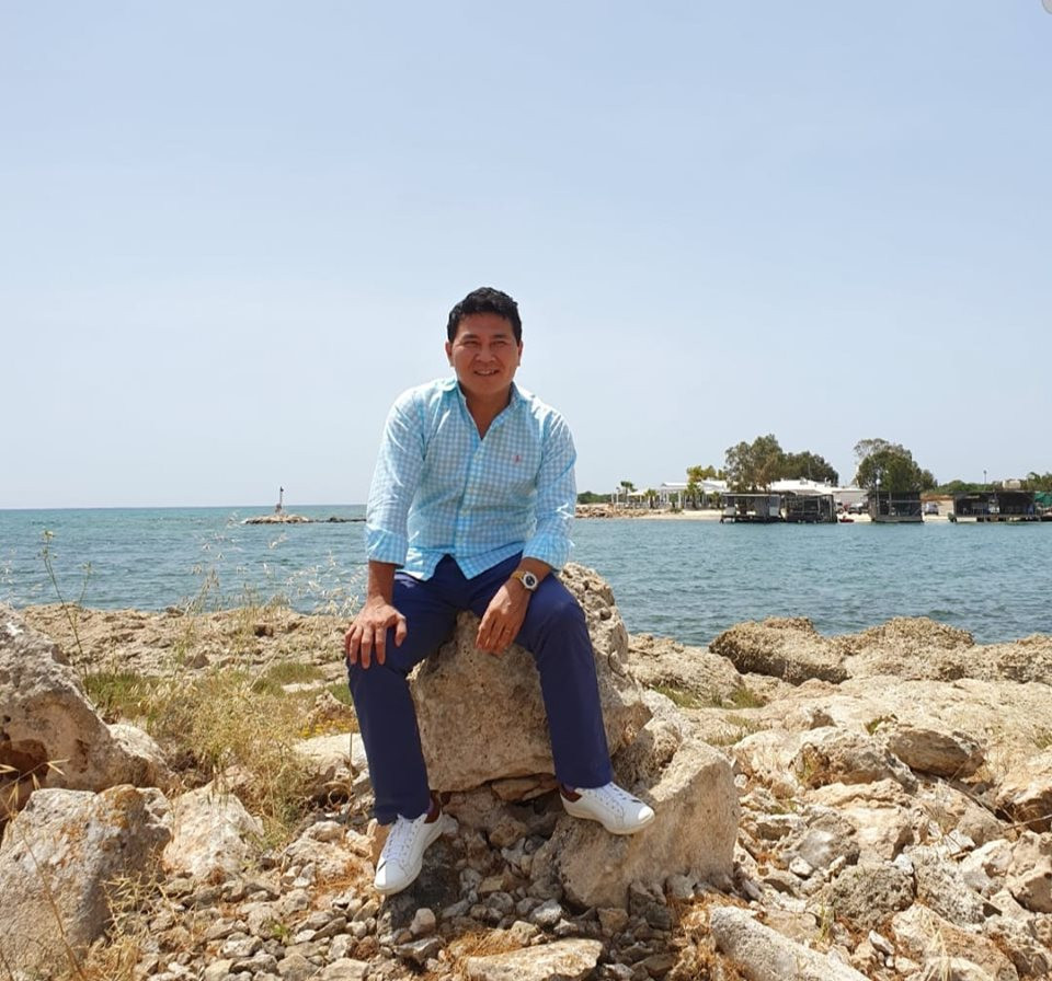 Doanh nhân Hoài Nam diện áo sơ mi kẻ với quần âu và đeo giày thể thao trẻ trung.