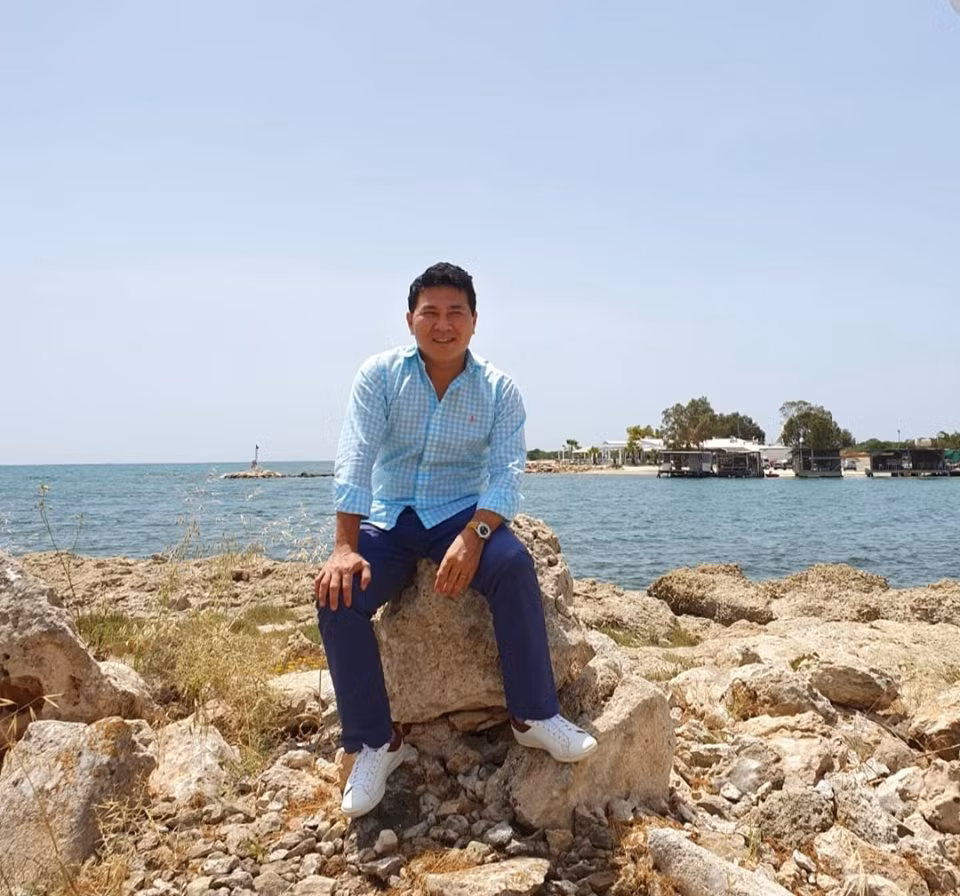 Doanh nhân Hoài Nam diện áo sơ mi kẻ với quần âu và đeo giày thể thao trẻ trung.