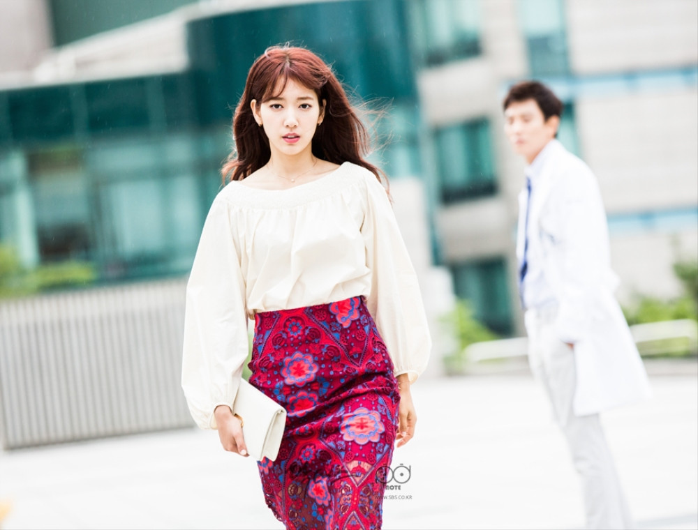 Cô phối áo sơ mi trắng với váy hoa văn đỏ cực kỳ sang chảnh và nổi bật.