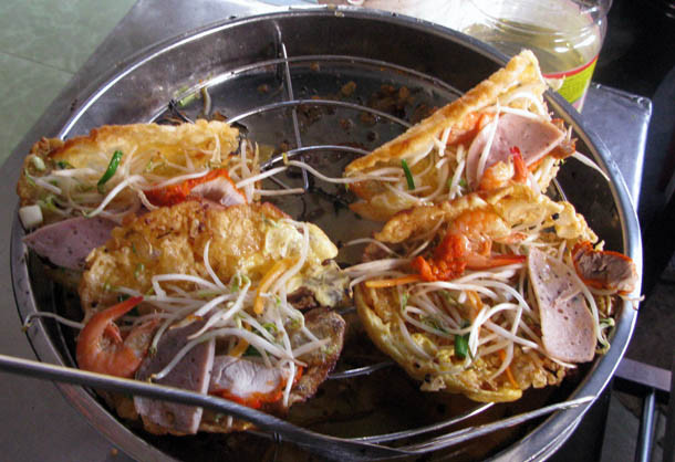 Bánh khoái: Vỏ bánh màu vàng chiên giòn được làm từ bột gạo và trứng, được gấp xung quanh lát thịt lợn nướng, xúc xích và tôm, sau đó phủ lên trên rau củ muối và giá đỗ tươi.