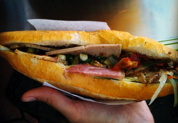 Bánh mì Phượng cũng là món ăn vặt nổi tiếng ở Hội An. Nó có kích cỡ nhỏ, vỏ giòn dễ vỡ, phần nhân đầy ắp các loại thịt, dưa góp, rau thơm và tương ớt, nước sốt đặc biệt làm nên thương hiệu của quán. Ảnh: Seriouseats.