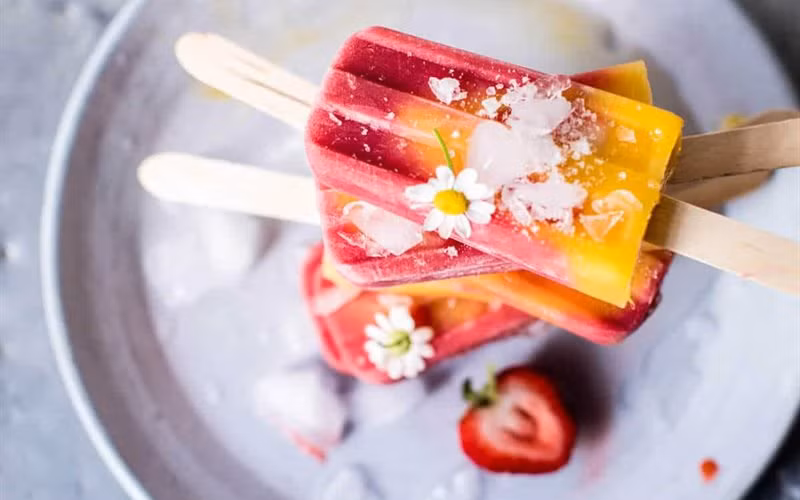 Cách làm: Xoài và dâu tây bỏ váo máy xay cho thật nhuyễn. Sau đó cho vào khuôn thành từng lớp, mỗi lớp chiếm khoảng 1/3 thể tích khuôn kem. Cắm que và bỏ vào ngăn đá tủ lạnh ít nhất 5 tiếng trước khi thưởng thức.