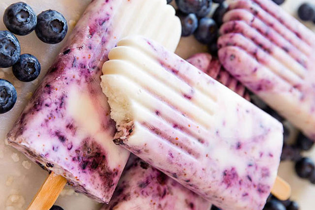 Kem chanh việt quất với nguyên liệu: 30 quả việt quất, bóc sạch vỏ, vỏ chanh, sữa chua. Món kem hoa quả này có vị ngọt thanh mát hết sức dễ chịu.