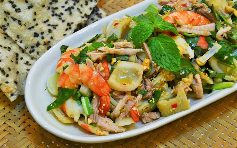 Gỏi mít non trộn tôm thịt: Nguyên liệu: 500 g mít non, 180 g thịt ba rọi, 180 g tôm tươi, 2 thìa canh vừng rang vàng, 1 bó rau răm, hành tây, gừng, hạt nêm, muối.