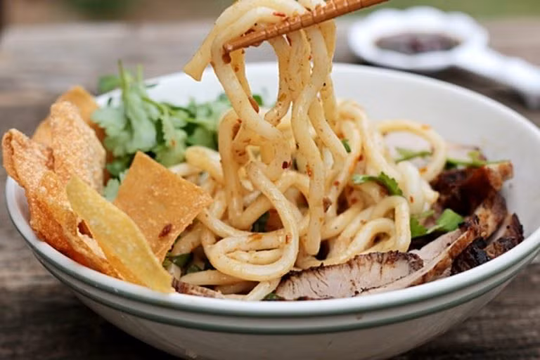 Cao lầu là một trong những món ăn không thể thiếu khi nhắc đến ẩm thực Hội An. Cao Lầu được chế biến từ những sợi mỳ dai giòn chứ không mềm nhão như những sợi mì bình thường. Bạn có thể trộn mỳ lên thoải mái không sợ nát, khi ăn thì người ta sẽ cho rau thơm, thịt xá xíu, chút nước dùng, tóp mỡ, bì lợn chiên giòn và một vài nguyên liệu riêng biệt khác.