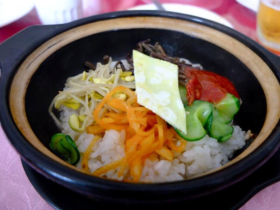 Bibimbap (Cơm trộn): Một món luôn là gợi ý tuyệt vời cho những người kén ăn khi đến Bình Nhưỡng là Bibimbap (cơm trộn). Thịt lợn, kim chi, đậu phụ, rau và gochujang (một loại tương ớt) được trộn đều với cơm trắng và nấu ngay tại bàn ăn trong chiếc bát bằng đá nóng là tất cả những gì bạn được trải nghiệm.