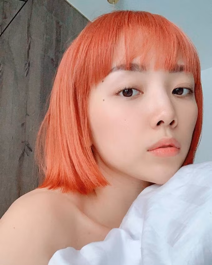 Tóc Tiên để tóc mái ngang và nhuộm màu cam sáng, giúp tôn lên các đường nét hài hòa trên gương mặt.
