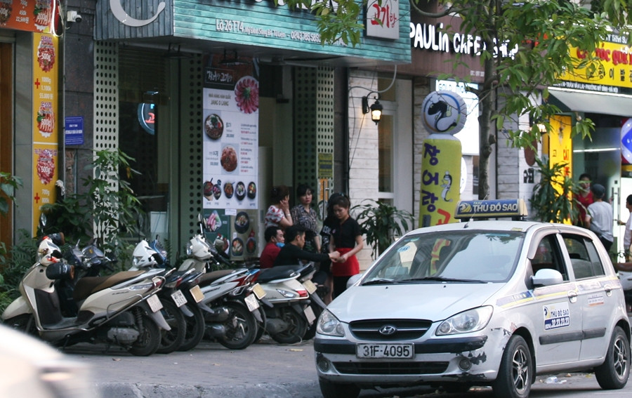 Nhân viên nhiều nhà hàng trên "phố Hàn Quốc" tập trung nói chuyện với nhau rôm rả vì vắng khách.