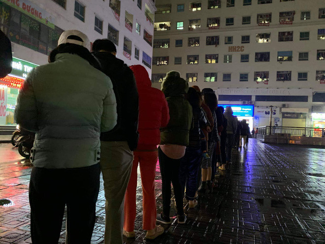 Càng gần khuya, lượng người dân kéo đến cửa hàng thuốc xếp hàng chờ mua khẩu trang càng đông.