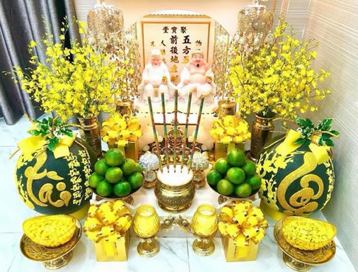 Ở giữa hai ông là một hũ gạo, một hũ muối và một hũ nước đầy. Ba hũ này chỉ đến cuối năm mới thay. Giữa bàn thờ đặt một bát nhang và cần tránh động bát nhang khi lau chùi bàn thờ. Lọ hoa được đặt bên tay phải, đĩa trái cây bên tay trái. Hoa cúng Thần Tài nên là hoa hồng, hoa cúc, hoa đồng tiền. Trái cây nên chọn ngũ quả. Xếp 5 chén nước thành hình chữ thập để tượng trưng cho ngũ phương và ngũ hành phát sinh phát triển. Ông Cóc để bên trái, sáng quay Cóc ra, tối quay Cóc vào.