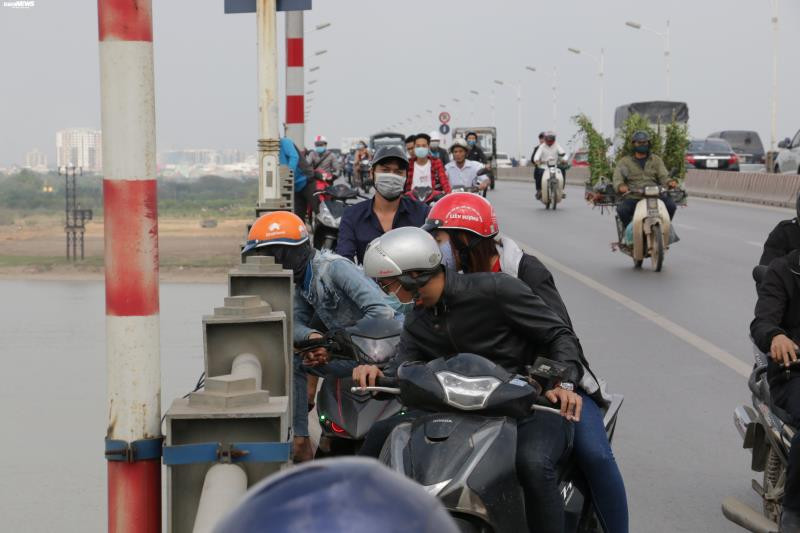 Cùng thời điểm, phía trên mặt cầu rất nhiều người hiếu kỳ dừng xe ngay tại thành cầu nhìn xuống lòng sông, theo dõi lực lượng giải cứu nạn nhân.