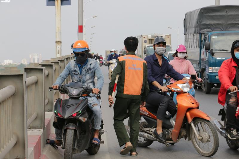 Bảo vệ điều hành giao thông của Công ty công trình giao thông Hà Nội phải liên tục nhắc nhở những người đứng ven đường di chuyển.
