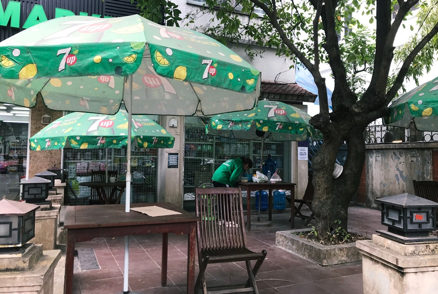 Bàn ghế ngồi chờ, nghỉ được sắp xếp bên ngoài siêu thị K-Market này bám đầy bụi và chẳng có vị khách nào.