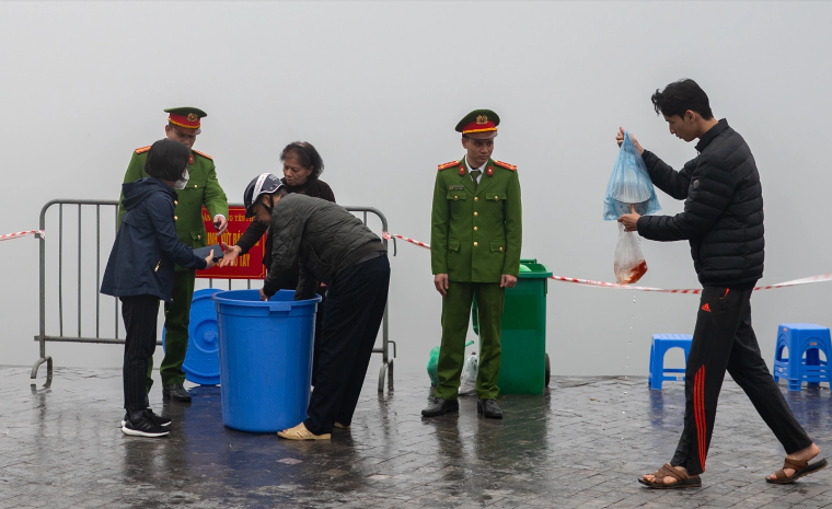 10h ngày 2/2 (tức 23 tháng Chạp), nhiều gia đình dắt theo trẻ nhỏ đến thả cá chép tại khu vực hồ Tây, cầu Long Biên, hồ Giảng võ... (Ảnh Dân Trí)