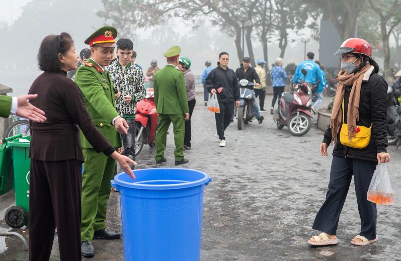 Hàng năm, khu vực gần Chùa Trấn Quốc nằm trong những điểm thả cá chép quen thuộc của người dân Hà Nội. Năm nay, Công an phường Yên Phụ (quận Tây Hồ) đã tổ chức hỗ trợ người dân tập trung cá vàng, mang ra sông Hồng thả, tránh ô nhiễm môi trường. (Ảnh Dân Trí)