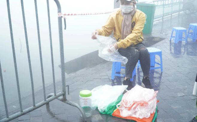 Túi nilong đựng cá chép được tình nguyện viên sắp xếp gọn gàng lại sau khi người dân sử dụng xong. (Ảnh Sức Khỏe và Đời Sống) 