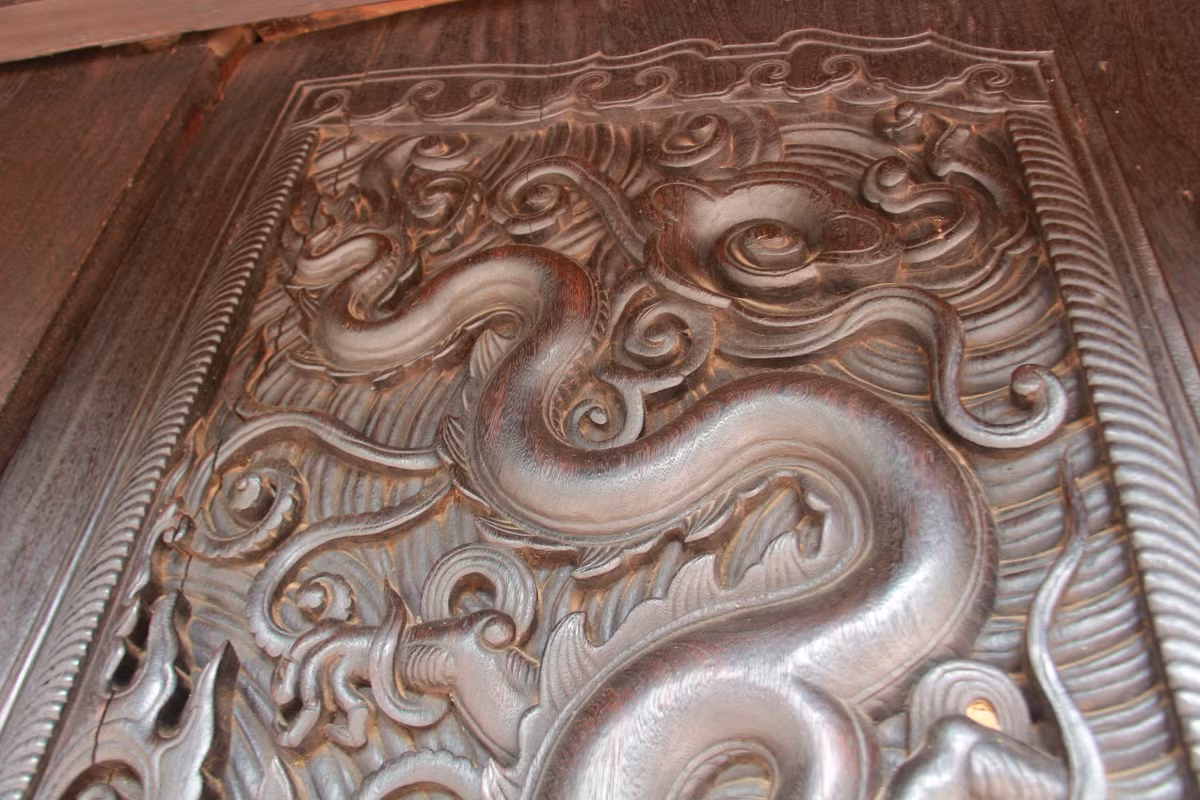 Phần dưới chạm bông hoa cúc nở đối xứng, phía trên chạm lá đề, cánh sen kép. 