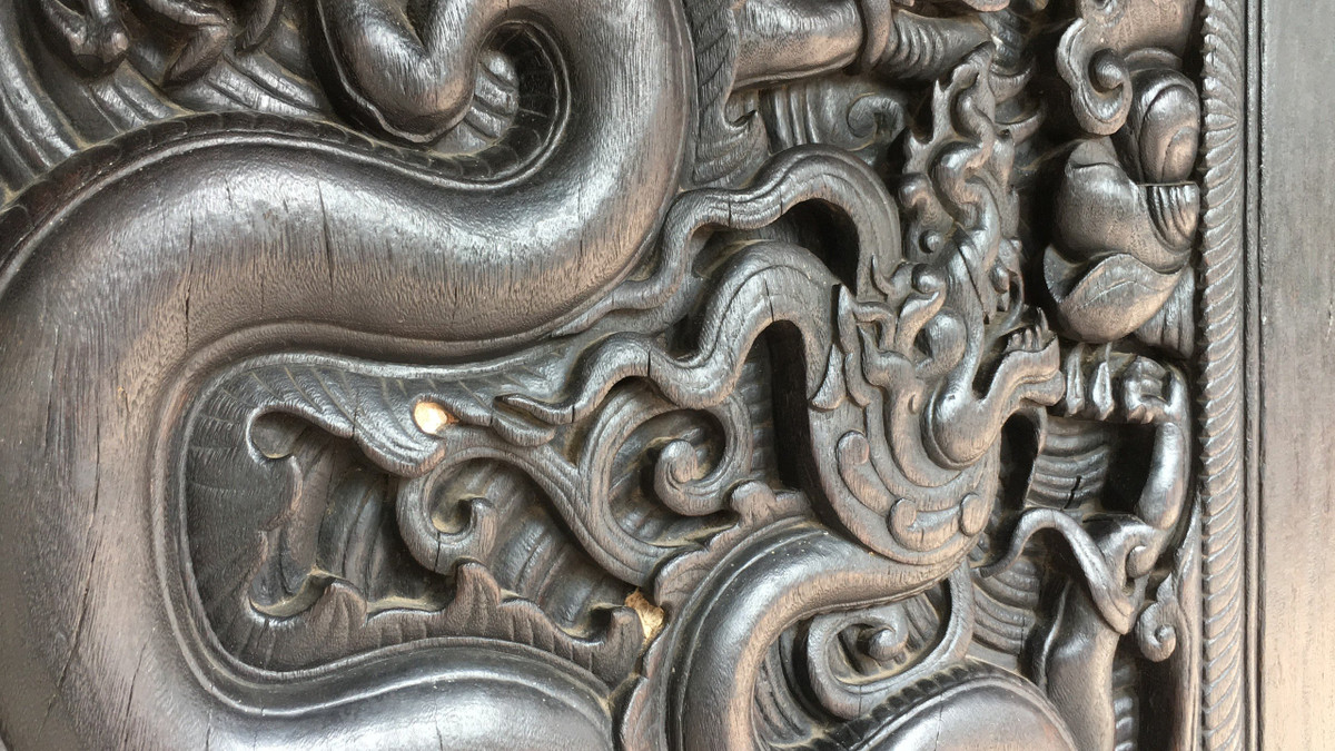 Rồng trong tư thế cuộn trong hình lá đề, xung quanh chấm mây lửa, giữa là bông sen nở.