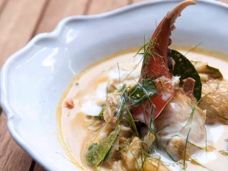 Trong hình là món cà ri nước cốt dừa nấu với cua biển xanh tại Bang Cốc, Thái Lan. Đây là món đặc sản đứng đầu danh sách 17 món ăn ngon nổi tiếng cho nhiều thành phố trên thế giới.