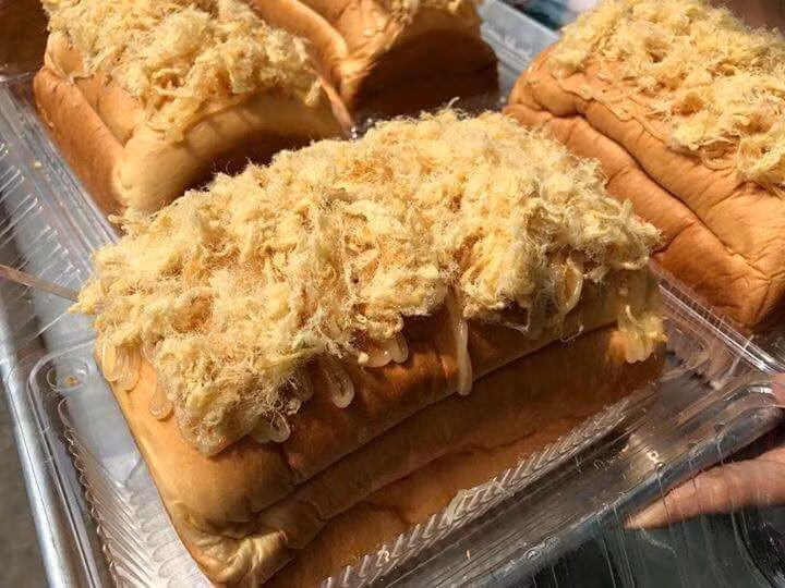 Không dừng lại ở đấy, bánh mì phô mai tan chảy có lớp vỏ được chế biến rất kì công, khi ăn sẽ cảm thấy vị béo ngậy, thơm nồng của sữa kết hợp với vị hơi mặn của ruốc đem đến cảm giác thích thú ngay từ miếng đầu tiên. Ảnh: Lozi. 