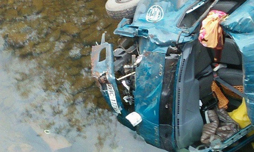 Chiếc xe tải nằm dưới lòng sông cạn.