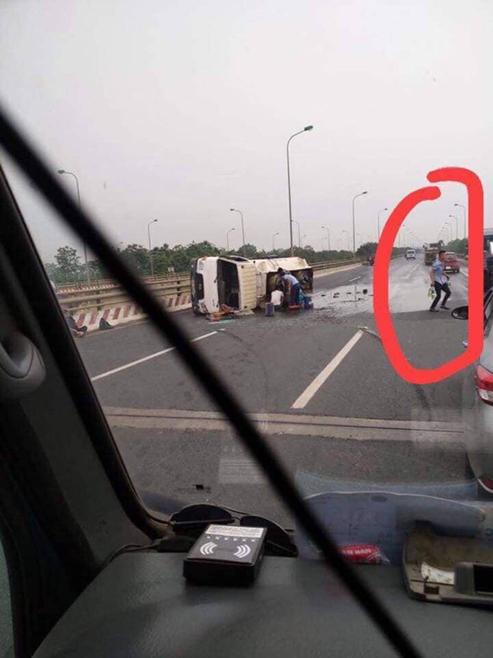 Người đàn ông cầm chai ra hứng xăng.