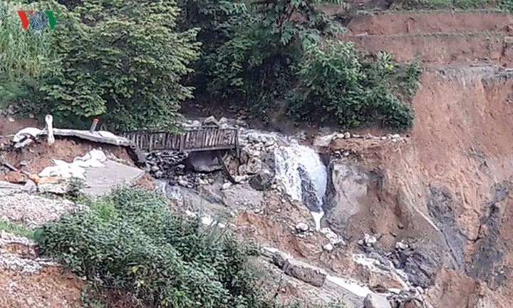 Cây cầu sắt bắc ngang qua suối dẫn vào bản cũng đã rơi mất một nhịp.