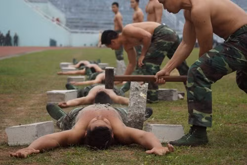 Biểu diễn đập vỡ bê tông kê trên đôi chân và trên vùng bụng và ngực. Ảnh: TienPhong.