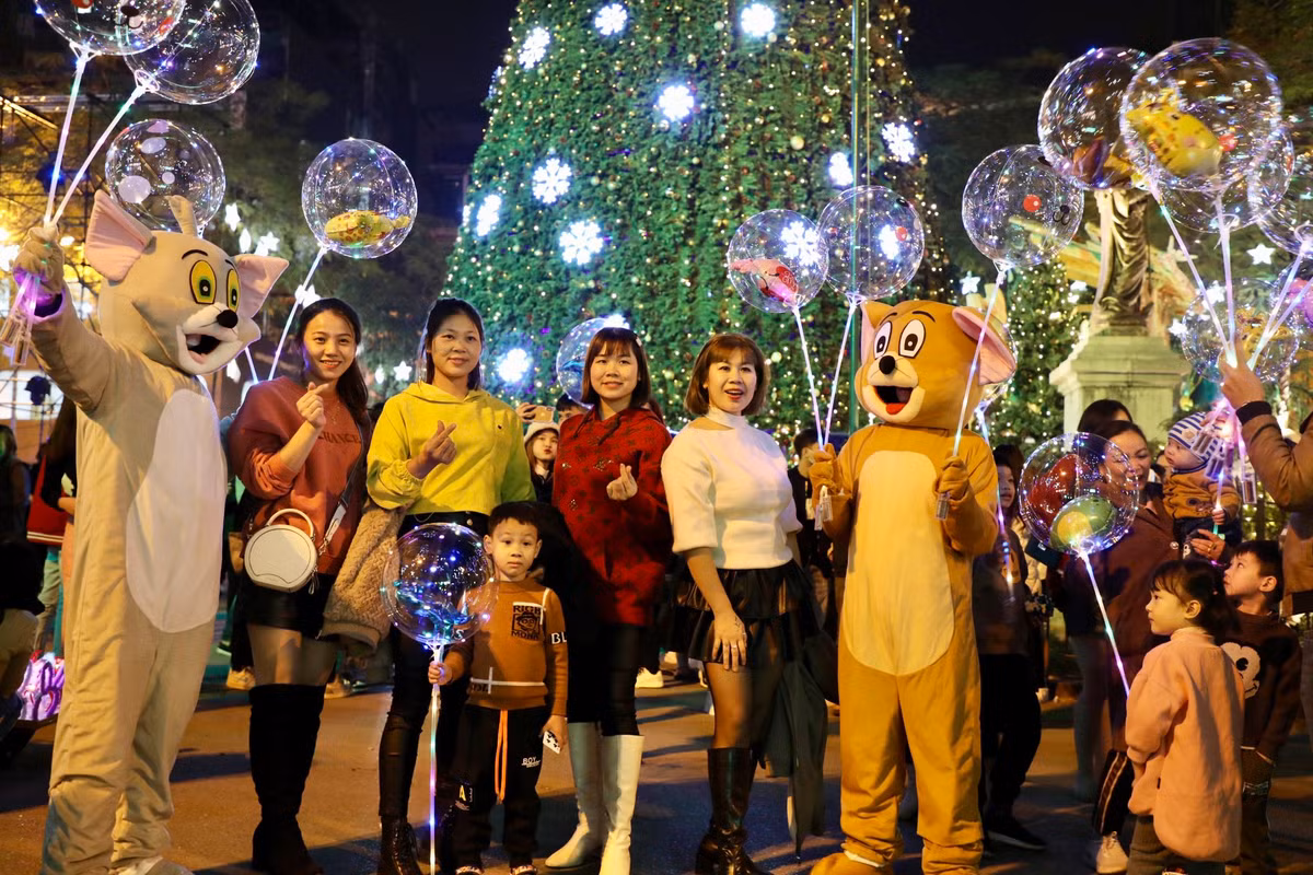 Người dân thích thú với ánh sáng lung linh từ cây thông Noel và những quả bóng bay đa sắc màu.