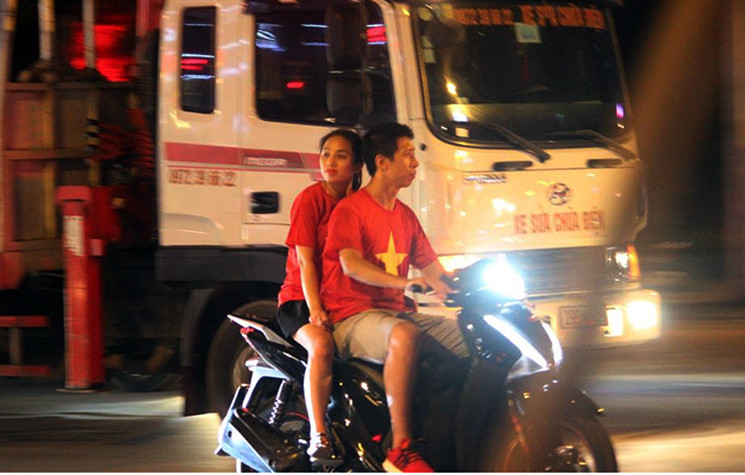 Cổ động viên mặc áo cờ đỏ sao vàng xuống đường ăn mừng các cầu thủ của chúng ta giành chiến thắng giòn giã.