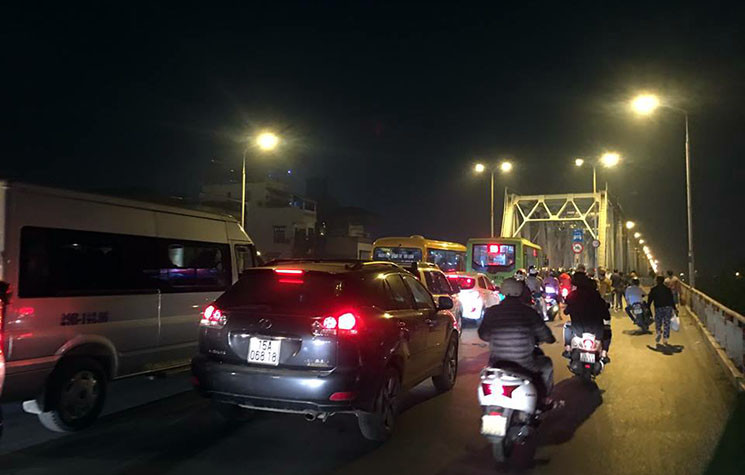 Để phục vụ công tác tìm kiếm chiếc ô tô gặp nạn, lực lượng chức năng đã cấm làn đường xe dành cho xe máy di chuyển từ Long Biên về trung tâm TP Hà Nội, các phương tiện phải dồn vào đi ở làn giữa.