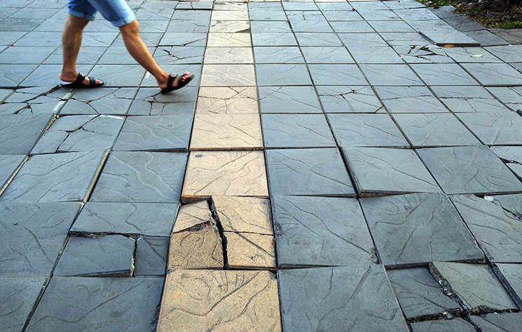 Đá vỉa hè vỡ, nằm nhấp nhô như sóng nước uốn lượn, người đi bộ đạp phải sẽ phát ra những tiếng rộp roạp.