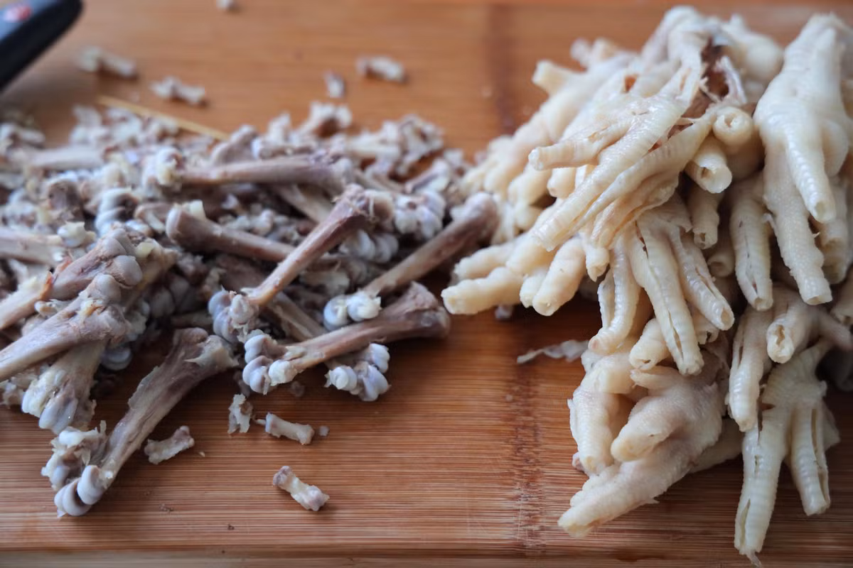 Dùng dao nhỏ rạch ở giữa từng ngón chân gà rồi lọc bỏ xương. Bí quyết là tách bỏ xương nhỏ trước rồi mới tách xương to cuối cùng. Như vậy chân gà sẽ được bóc sạch sẽ, không bị gãy, nát.