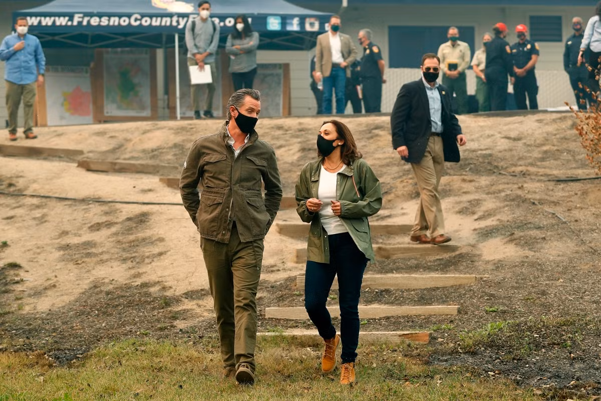 Khi Kamala Harris cùng Thống đốc California - Gavin Newsom - đi thăm khu vực bị thiệt hại nặng do hỏa hoạn ở Auberry, California, Mỹ. Bà kết hợp áo thun trắng với áo khoác kiểu quân đội, quần jeans bó và đôi boots vàng phong cách hip-hop của nhà mốt Timberland.