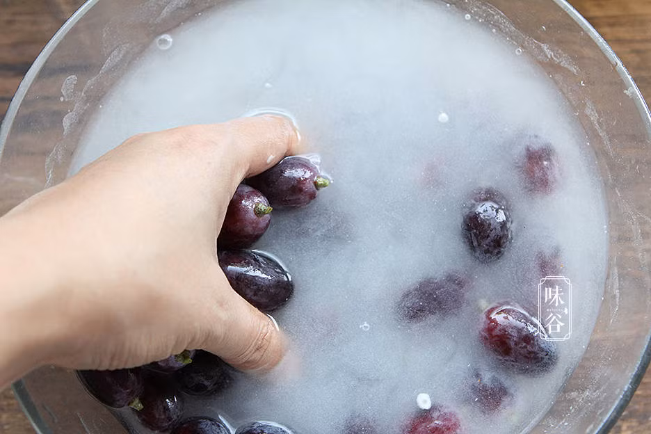Chuẩn bị một cái chậu lớn, xả nước, sau đó thêm baking soda (muối nở) và bột mì vào chậu, khuấy cho đều dung dịch này rồi đặt nho đã cắt vào, để yên trong khoảng 10 phút. Tiếp đó dùng tay nhào nhẹ, cuối cùng rửa lại bằng nước sạch một lần nữa, lần này nho đã trở nên siêu sạch, trẻ có thể ăn cả vỏ mà không cần lo lắng.