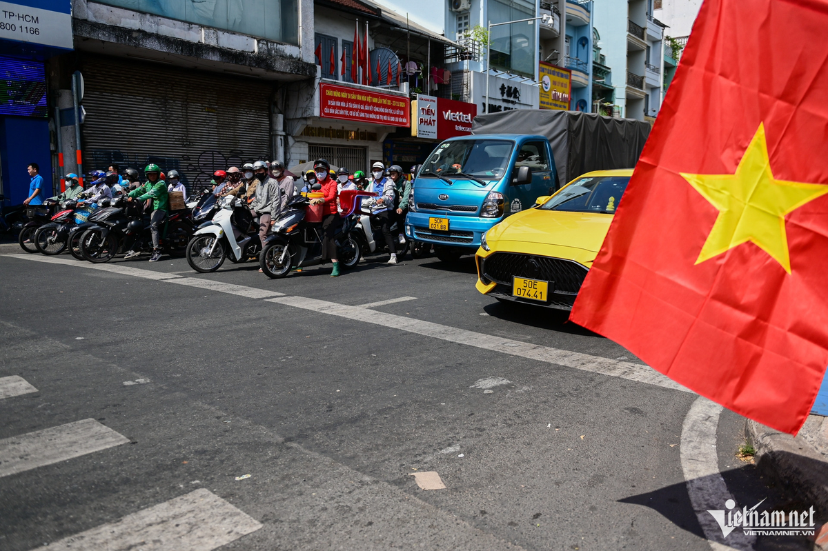 Giữa trưa nắng nóng, dòng người nghiêm chỉnh chấp hành tín hiệu dừng chờ đèn đỏ tại vòng xoay Bưu điện Chợ Lớn (quận 5).