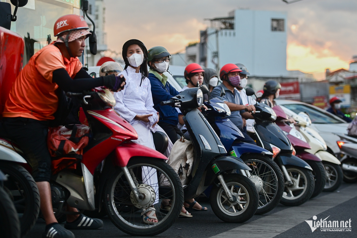 Giờ tan tầm, người lao động, tài xế giao hàng, học sinh... vẫn chấp hành tín hiệu đèn đỏ, dừng đỗ sau vạch kẻ đường tại nút giao Phạm Văn Đồng với đường Lê Quang Định.