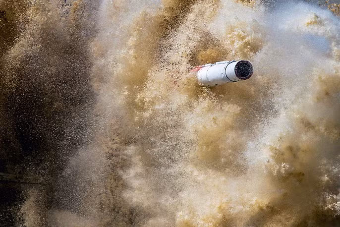 Nòng súng xe tăng Iran thò ra trong đám khói bụi.