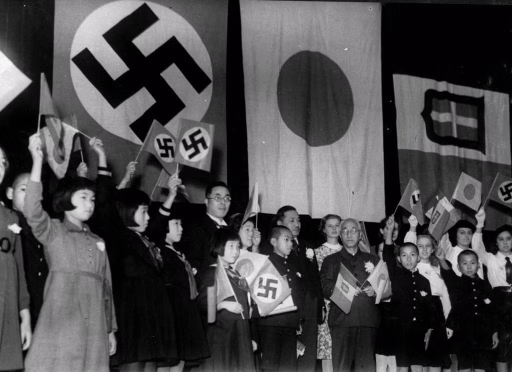 Trẻ em cầm cờ của 3 nước: Đức, Italy và Nhật Bản nhân sự kiện ký kết hiệp ước liên minh giữa 3 quốc gia này vào ngày 17/12/1940. Đây là một trong những bức ảnh ghi lại tình hình Nhật Bản trong Chiến tranh thế giới 2.