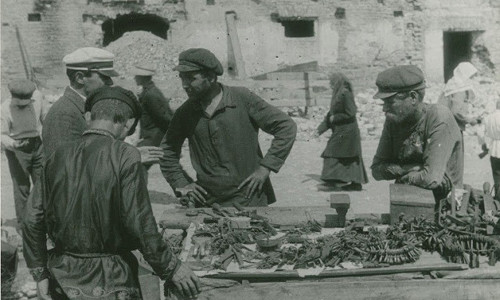 Những người đàn ông Liên Xô đứng trước một sạp hàng kim khí.