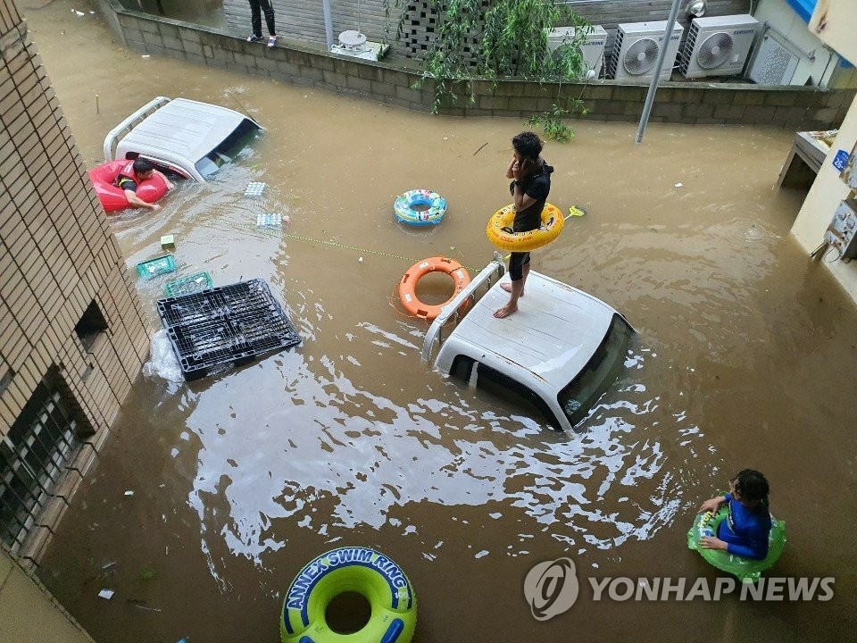 Người dân chờ được giải cứu khỏi khu chợ ngập lụt do mưa lớn ở Hadong, Hàn Quốc, hôm 8/8.