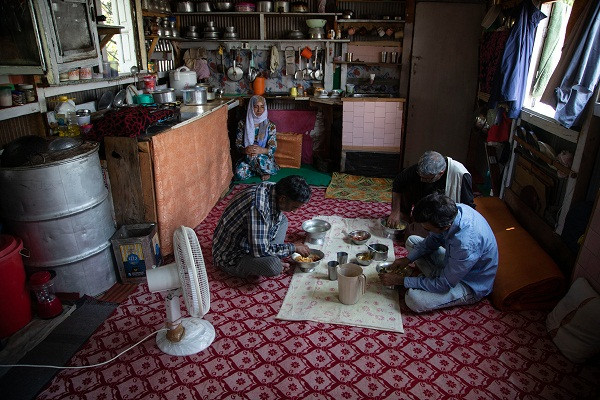 Ghulam Qadir Ota và các thành viên trong gia đình ngồi ăn trong nhà thuyền. "Chúng tôi không kiếm được đồng nào trong một năm nay. Tất cả những gì chúng tôi có là những chiếc thuyền này. Chúng tôi không có cách nào khác để kiếm tiền", Ota chia sẻ.