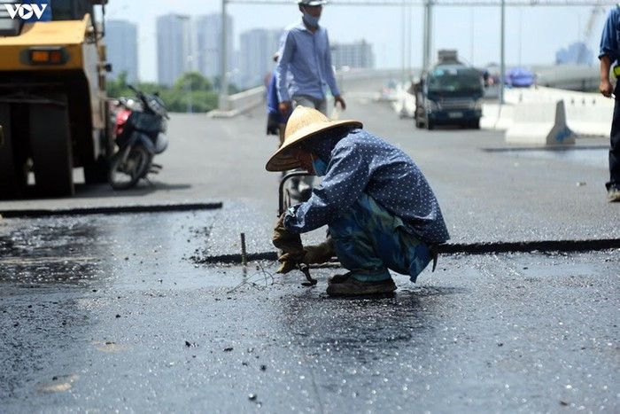 Công nhân đội nắng thi công mặt cầu để đảm bảo theo đúng tiến độ.