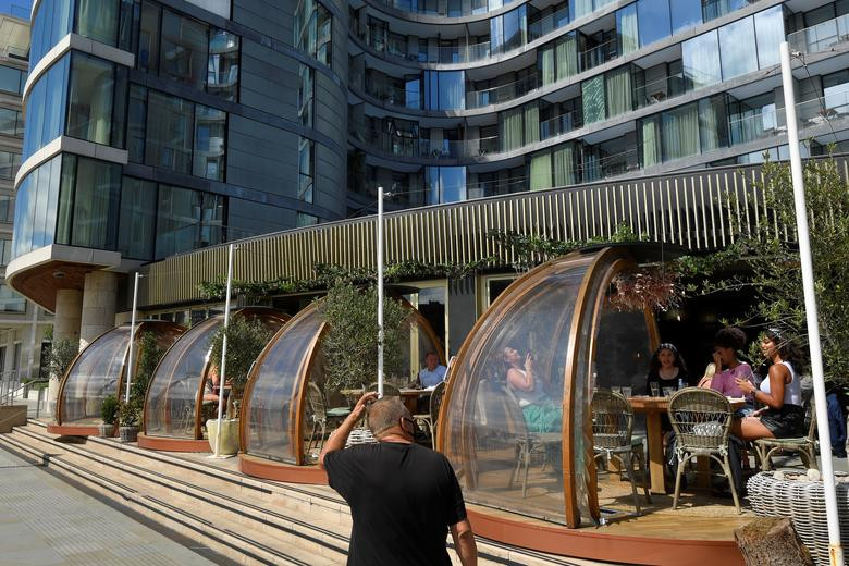Các thực khách dùng bữa trong buồn ăn riêng tại một nhà hàng ở London (Anh) ngày 6/8.