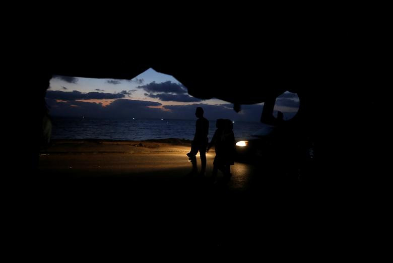 Mọi người đi bộ trên một con phố trong lúc mất điện tại khu trại tị nạn Beach ở Thành phố Gaza, ngày 18/8, sau khi nhà máy điện Gaza đóng cửa giữa căng thẳng với Israel.