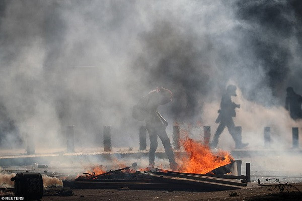 Cảnh sát bắn hơi cay vào đám đông người biểu tình khi họ cố gắng vượt qua hàng rào chặn một con phố dẫn đến tòa nhà Quốc hội.