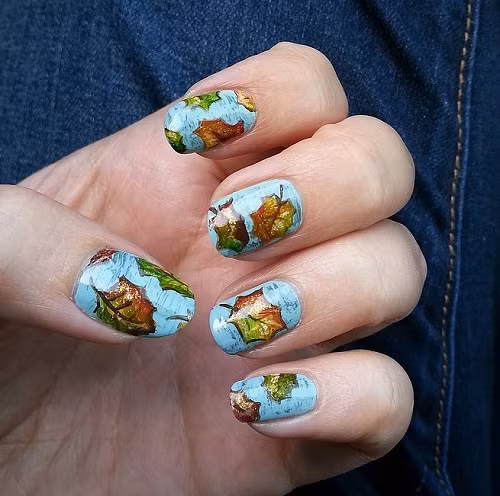 Đôi tay trở nên nổi bật hơn với chiếc lá trên nền xanh nước biển.