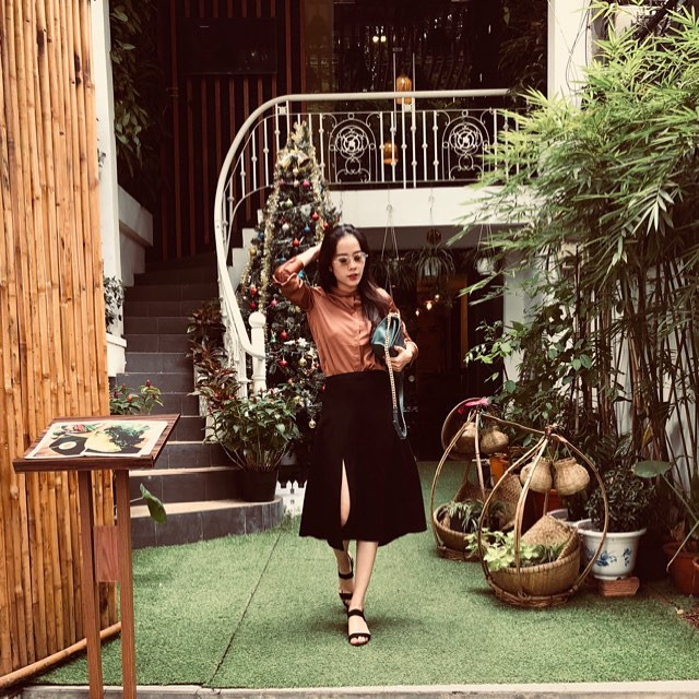 Cách phối áo sơ mi nâu với váy đen xẻ tà khiến Nam Em già hơn tuổi.