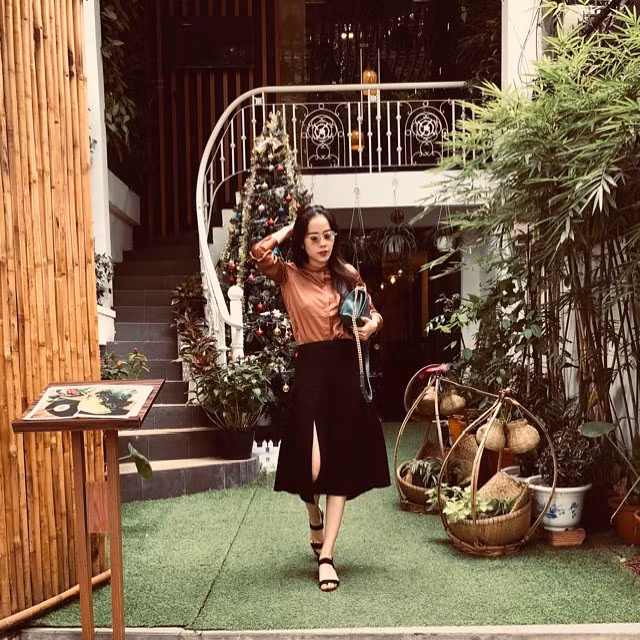 Cách phối áo sơ mi nâu với váy đen xẻ tà khiến Nam Em già hơn tuổi.