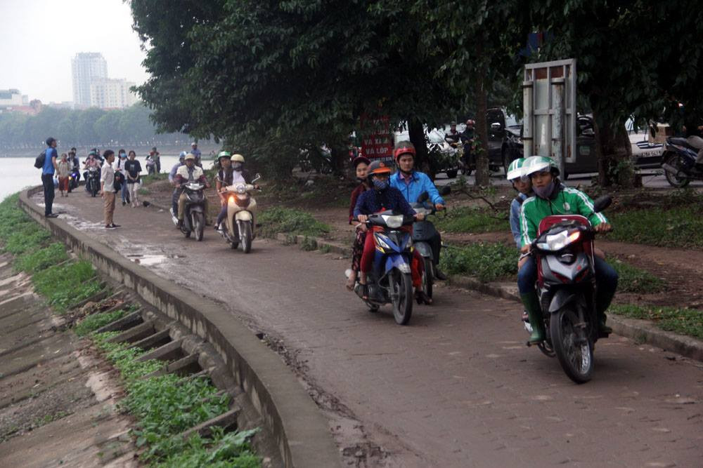 Tuyến đường Nguyễn Hữu Thọ ùn tắc nên người dân băng qua đường hồ Linh Đàm để thoát tắc. Ảnh: Trần Thường